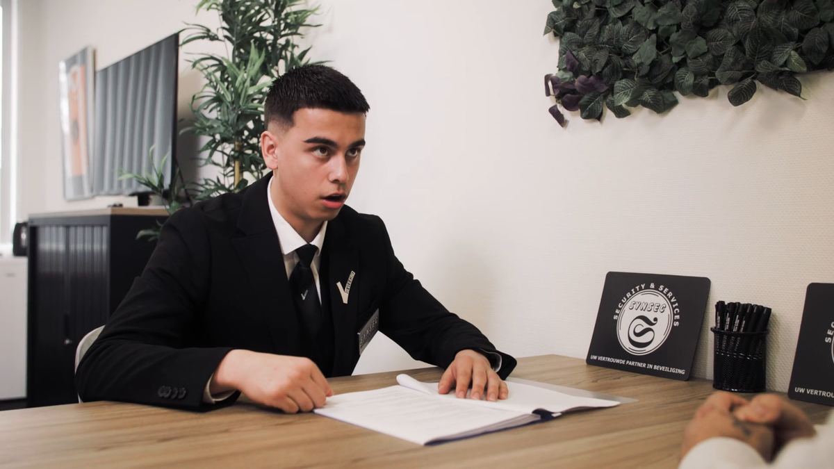 Medewerker van Synsec bespreekt een beveiligingsvoorstel aan tafel